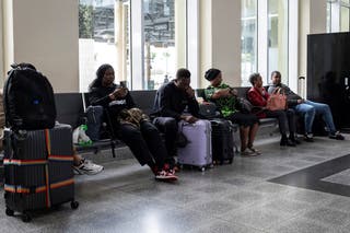 Пътуващите чакат на международното летище Пиарко, тъй като полетите бяха забавени и отменени поради урагана Берил